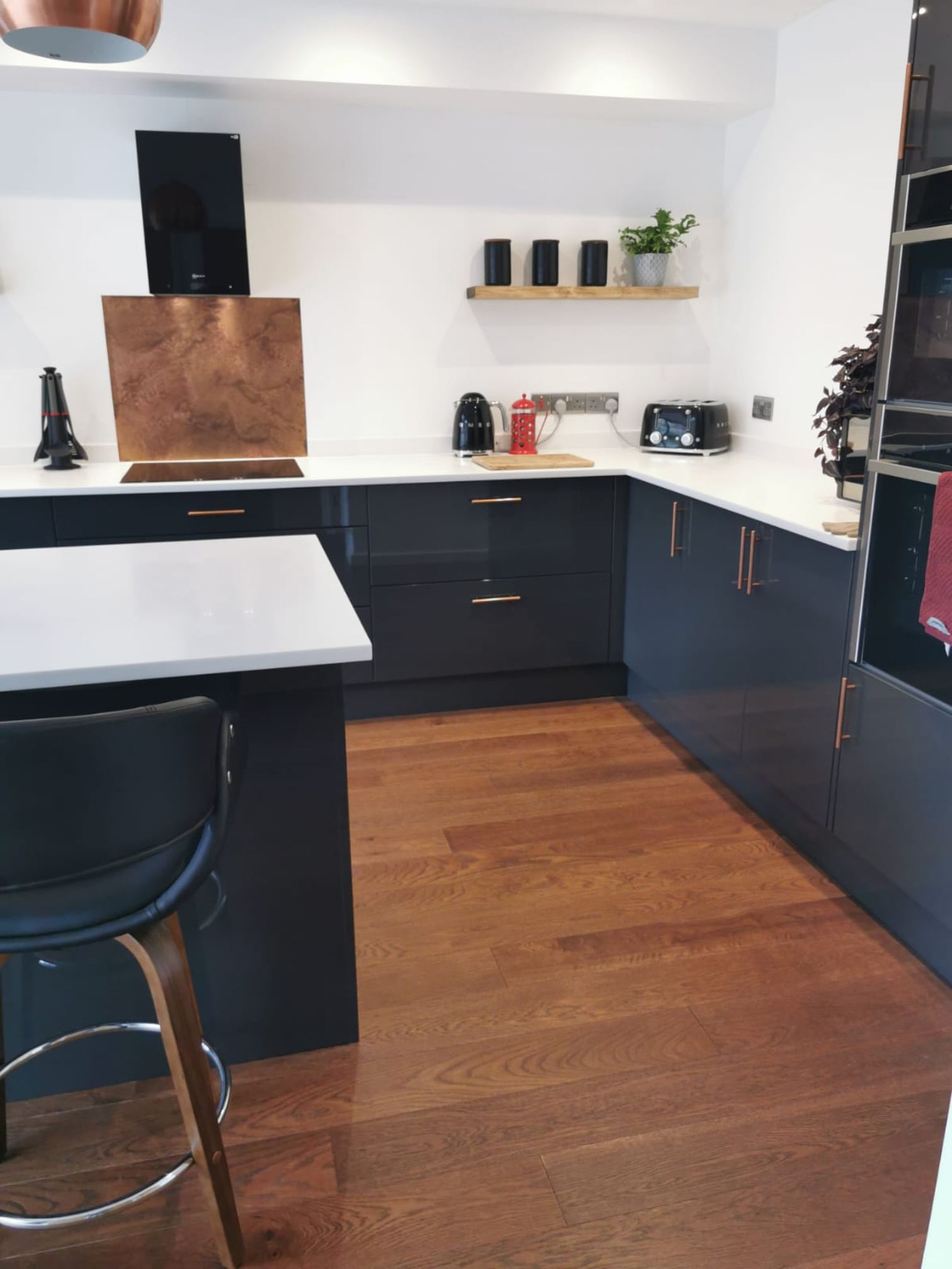 A modern dark blue kitchen with a Woodpecker - Harlech Cognac Oak